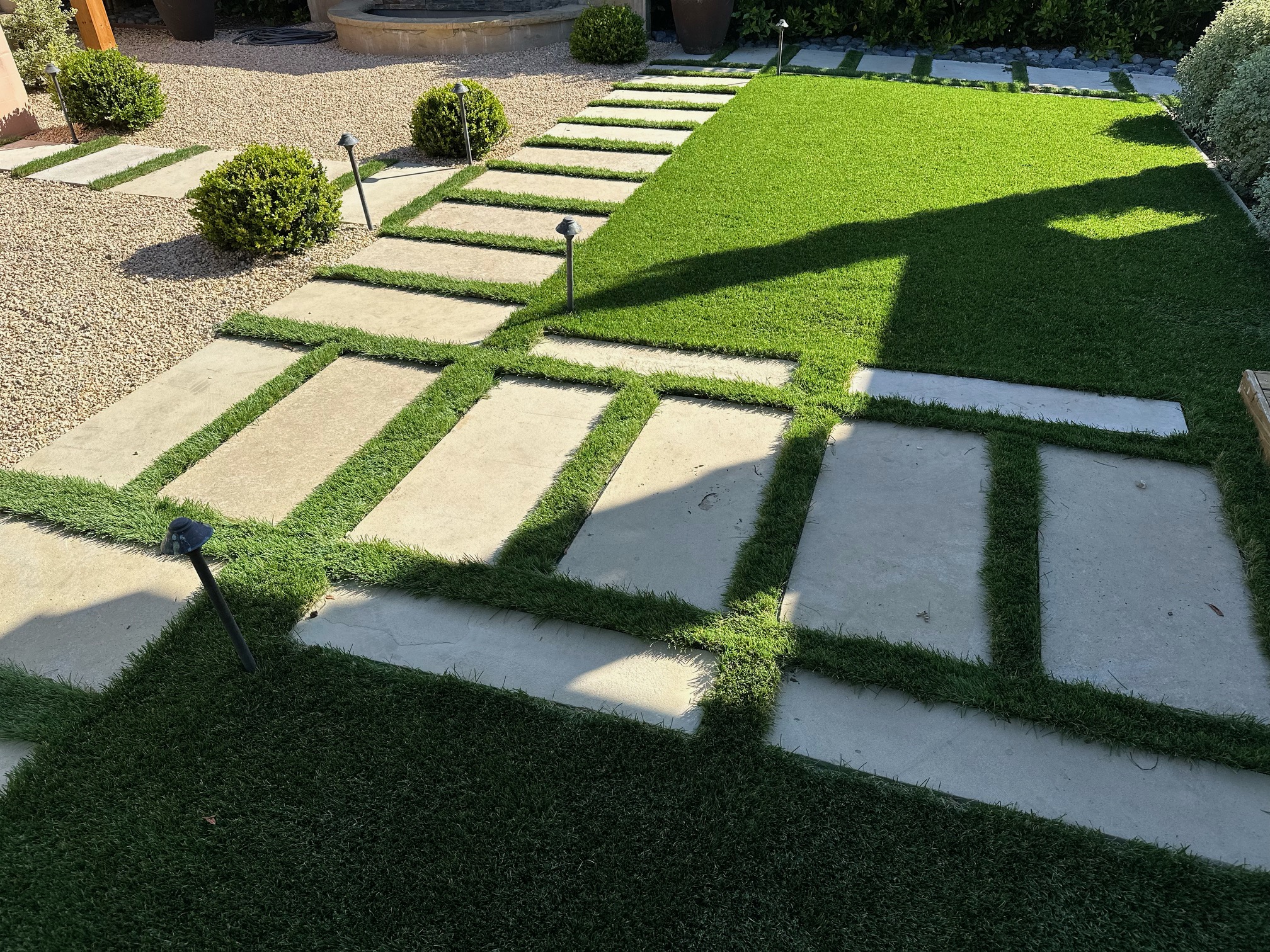 Modern concrete paver and turf grid design with path lighting in a Santa Barbara landscape.