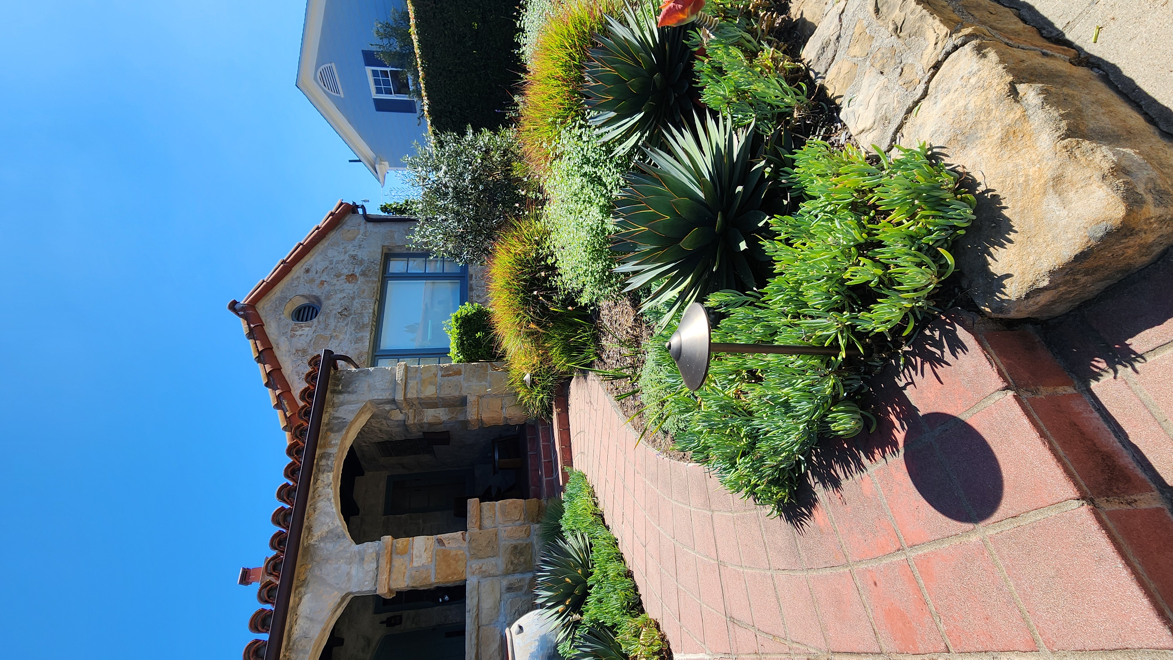 Curved terracotta paver walkway through a drought-tolerant Santa Barbara garden.