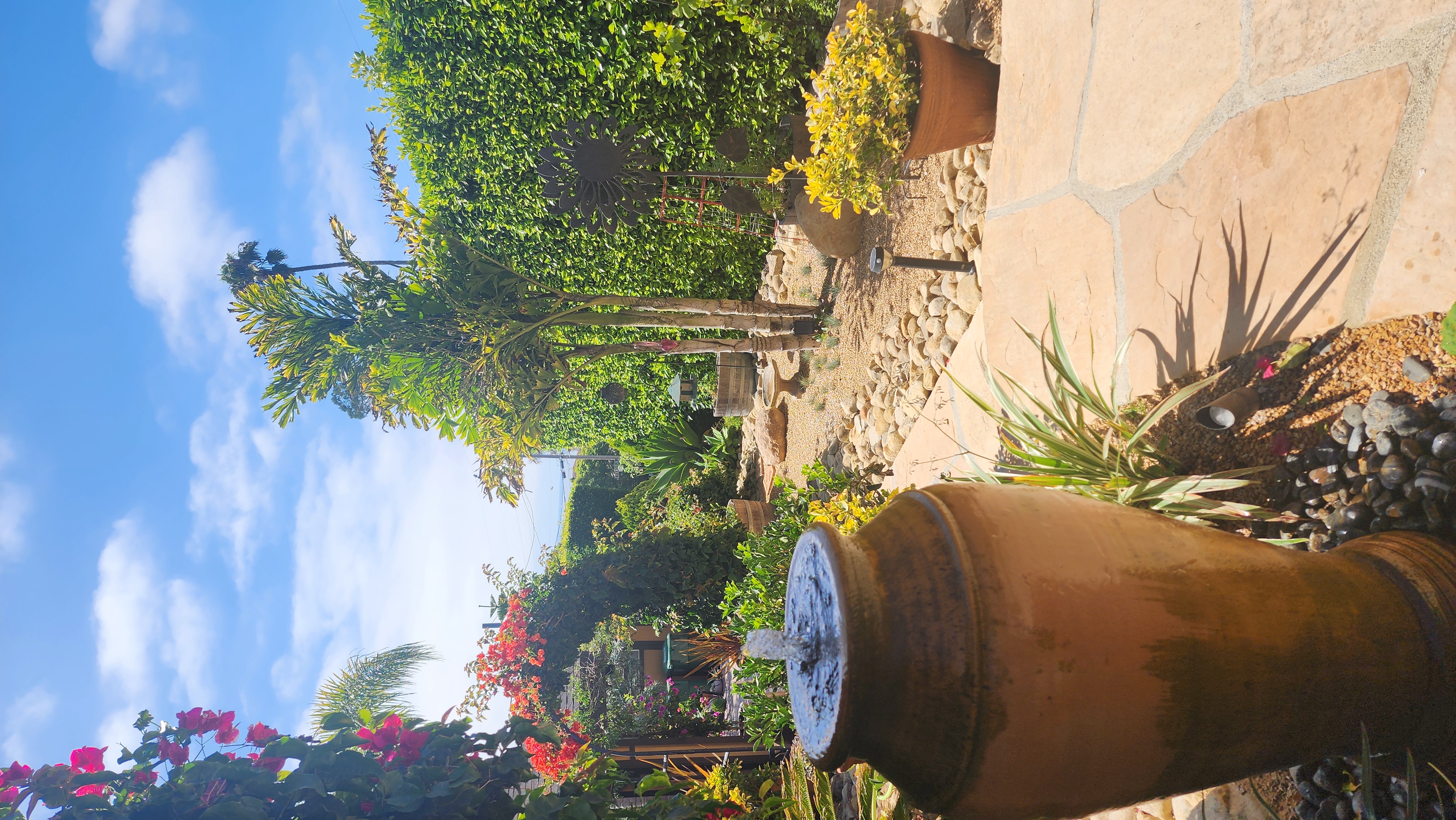Ceramic urn fountain with flagstone patio in a tropical Santa Barbara garden.