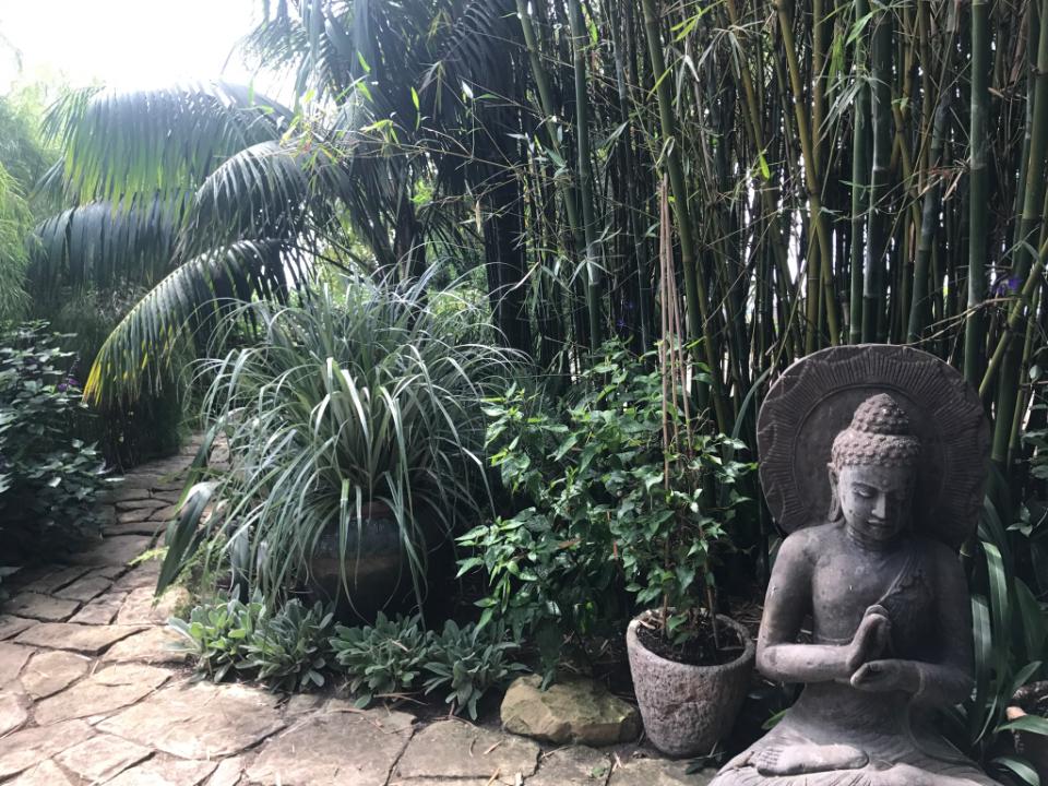 Zen garden corner with stone Buddha statue and bamboo in a Santa Barbara landscape.