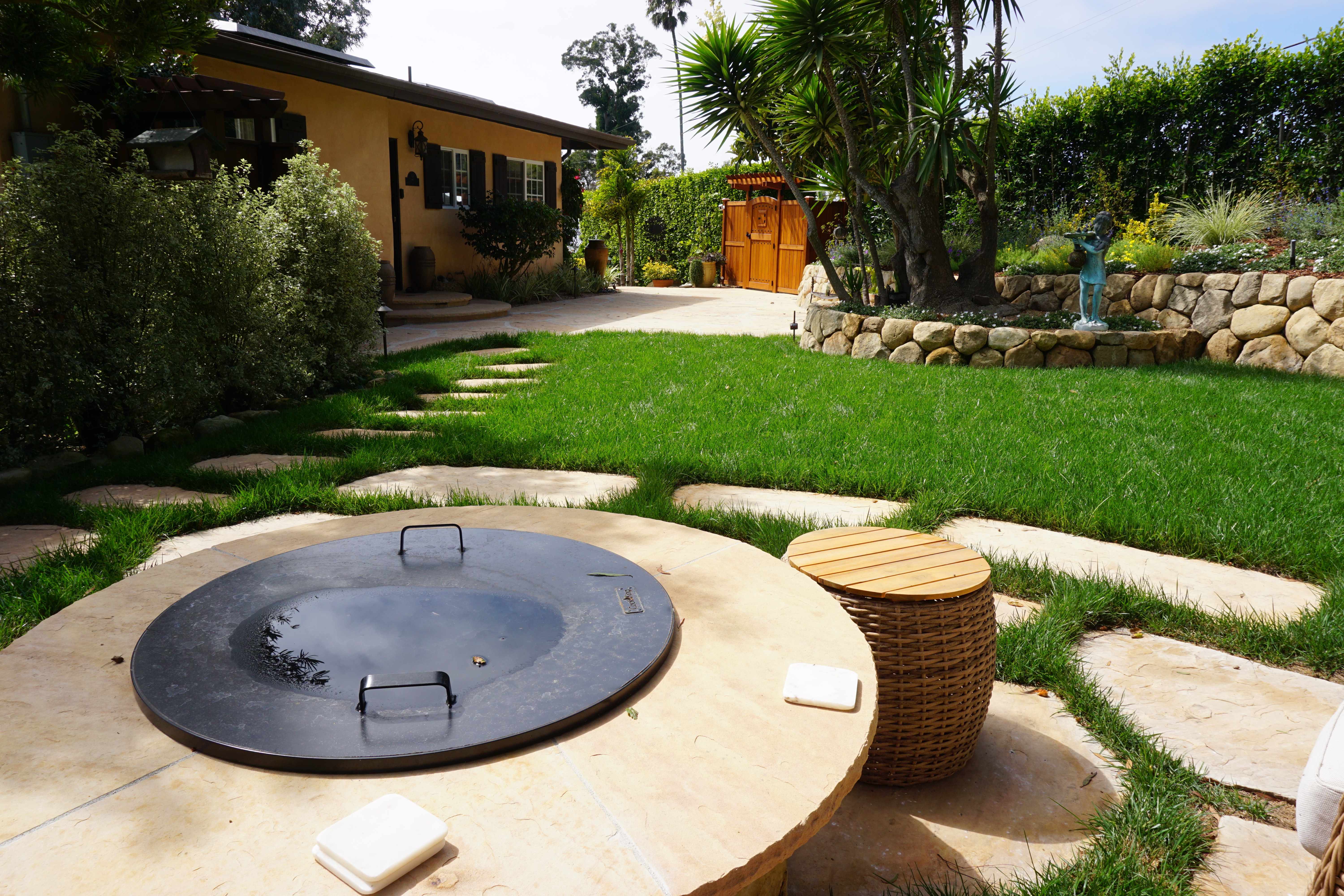 Circular stone fire pit with flagstone stepping stones in a Santa Barbara landscape.