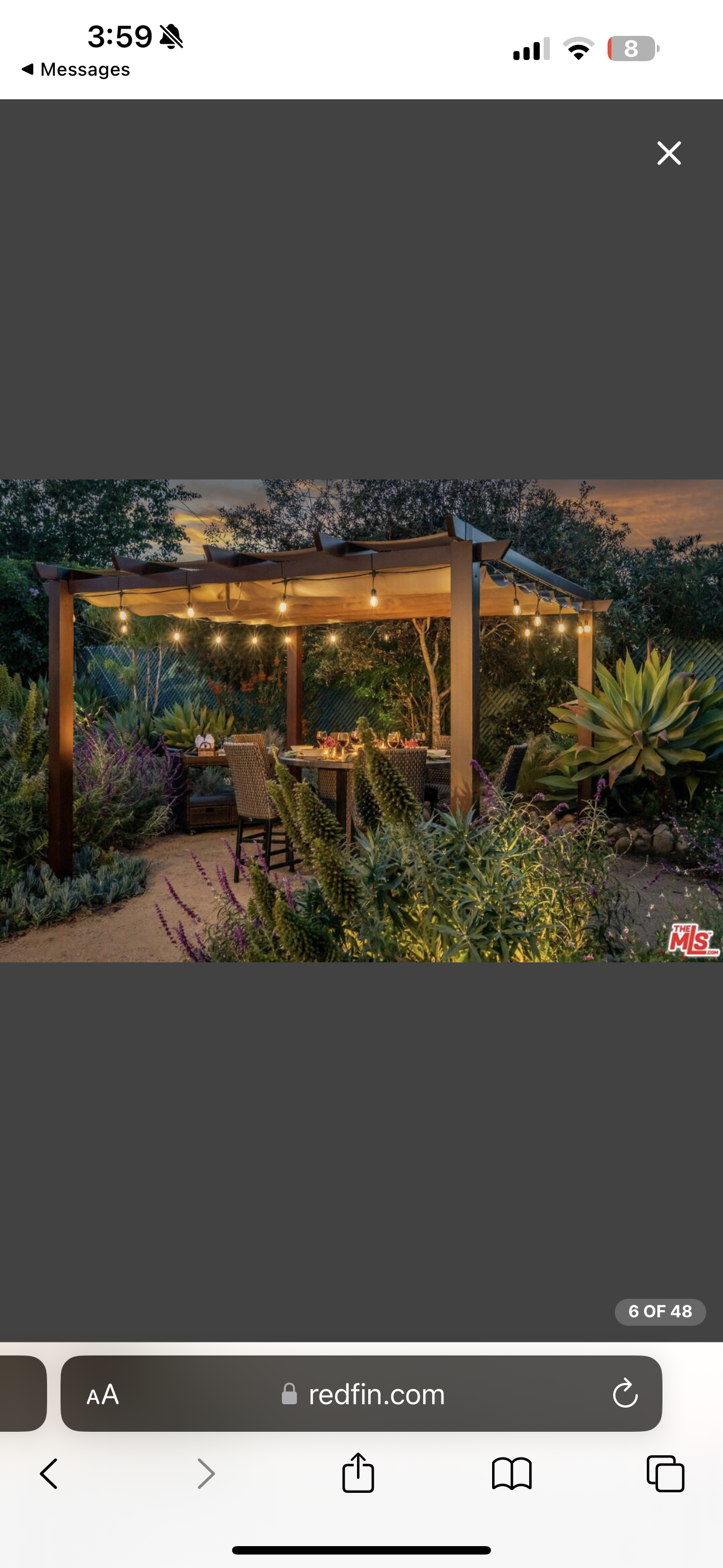 Illuminated pergola dining area surrounded by xeriscape plantings in Santa Barbara.