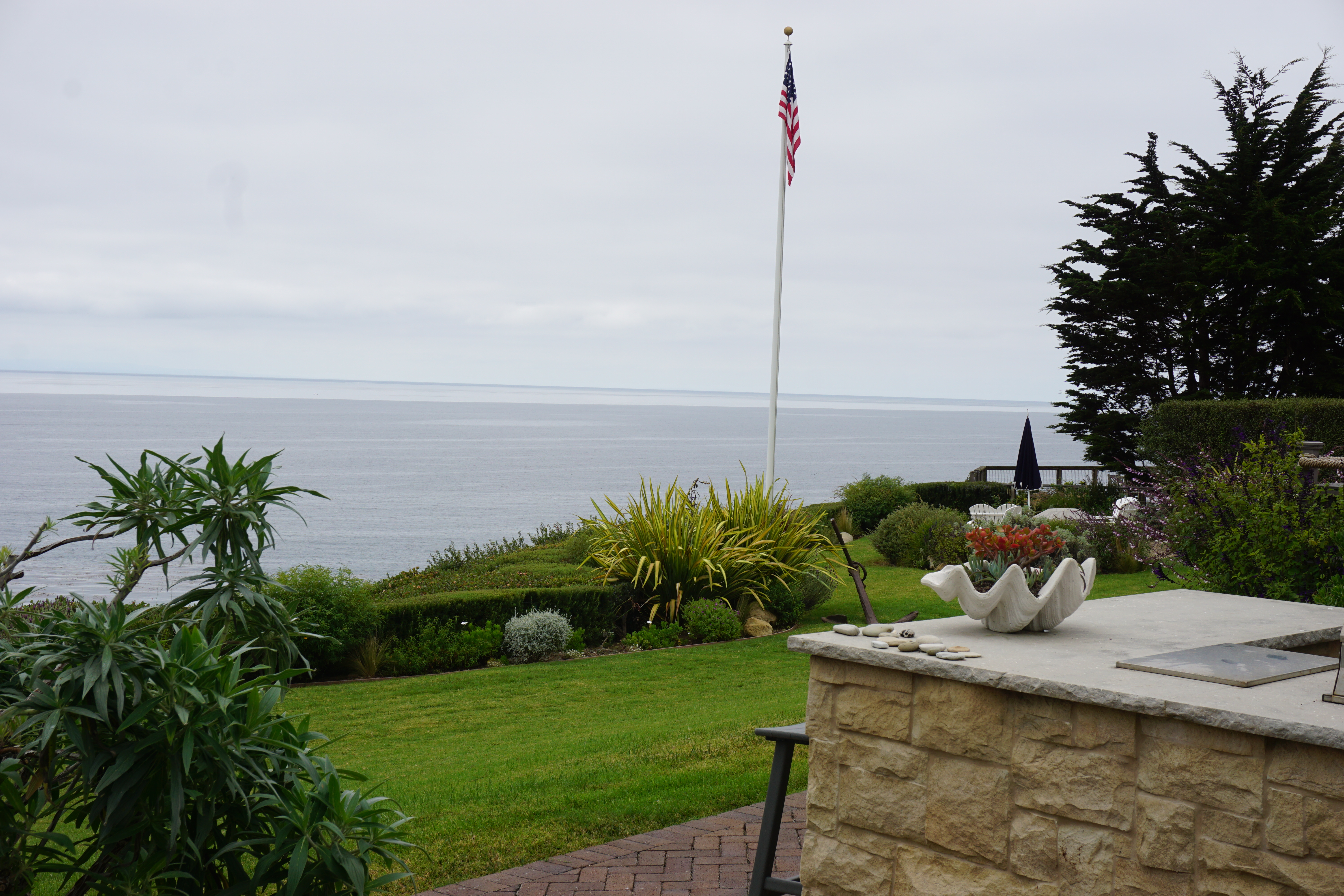 Stone outdoor kitchen counter overlooking the Pacific Ocean at a Santa Barbara bluff home.